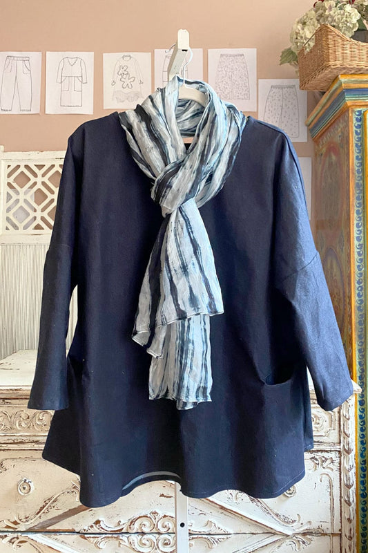 Black and white silk scarf wrapped around the neck of a denim aline top