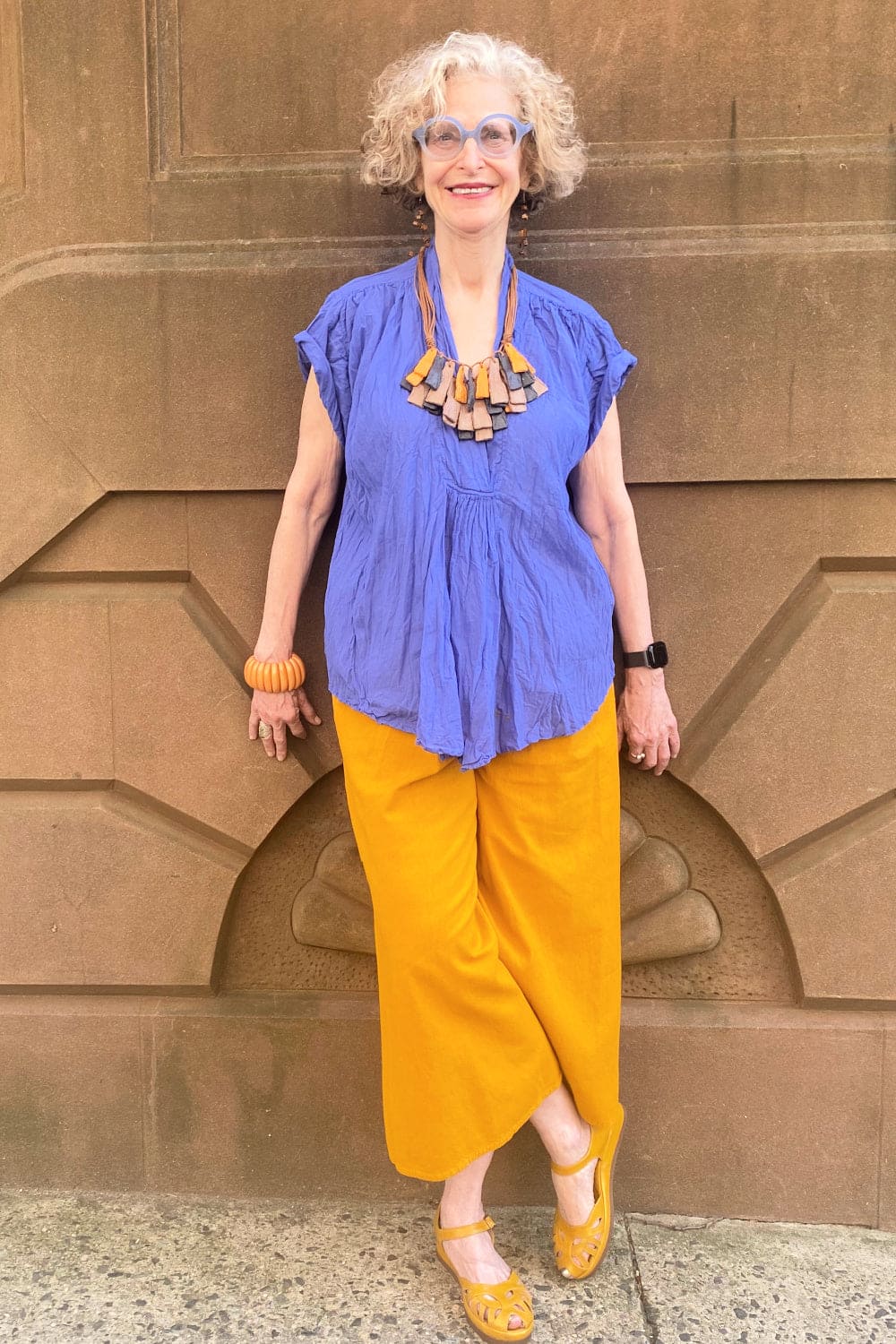 Periwinkle v neck short sleeve cotton women's top worn with tumeric colored full leg pant.