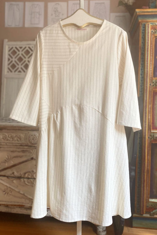 Natural color linen with navy pinstripe tunic dress hanging on a vintage hanger.