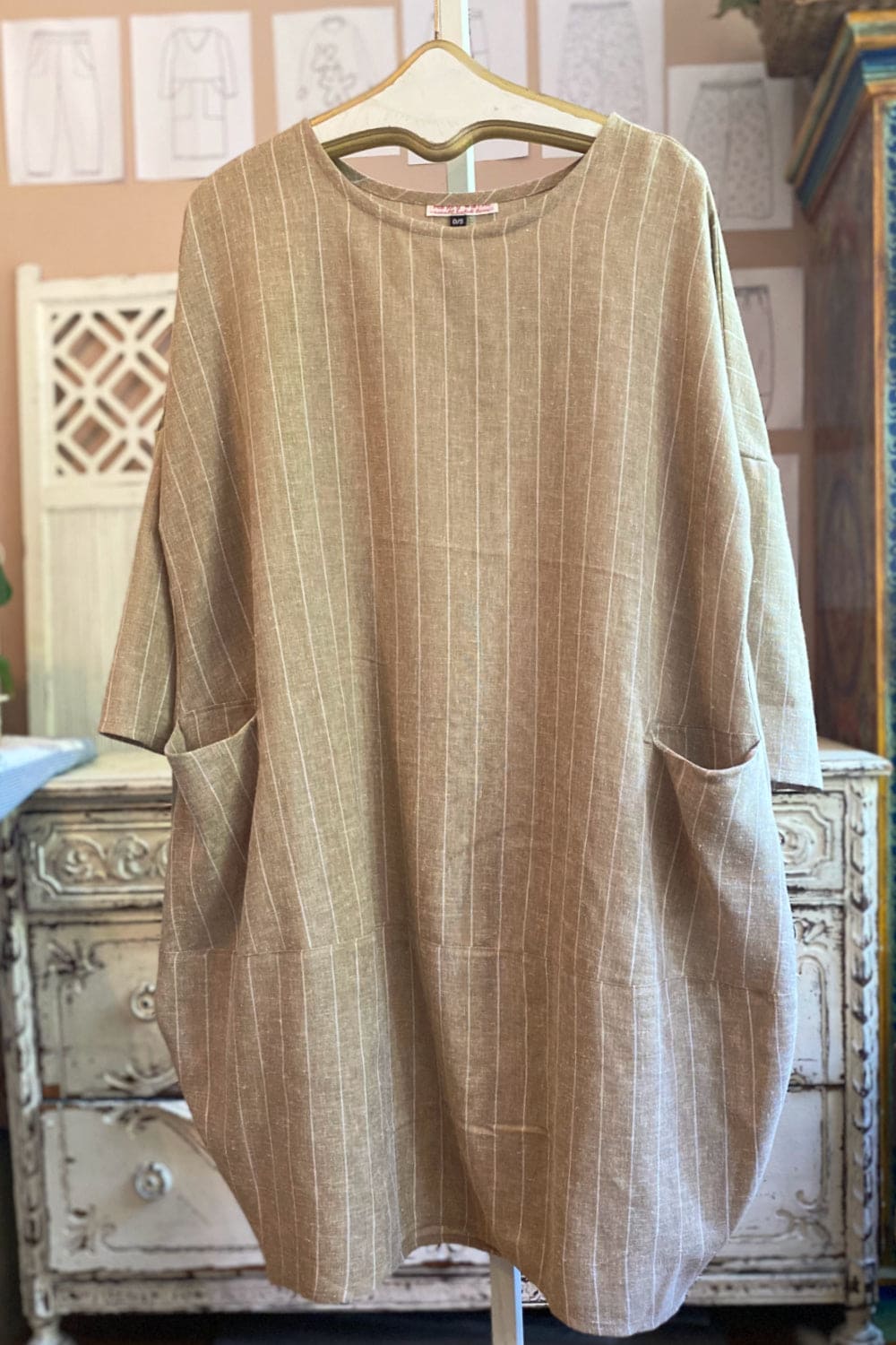 Long sleeve linen dress with a full cut and two front pockets.