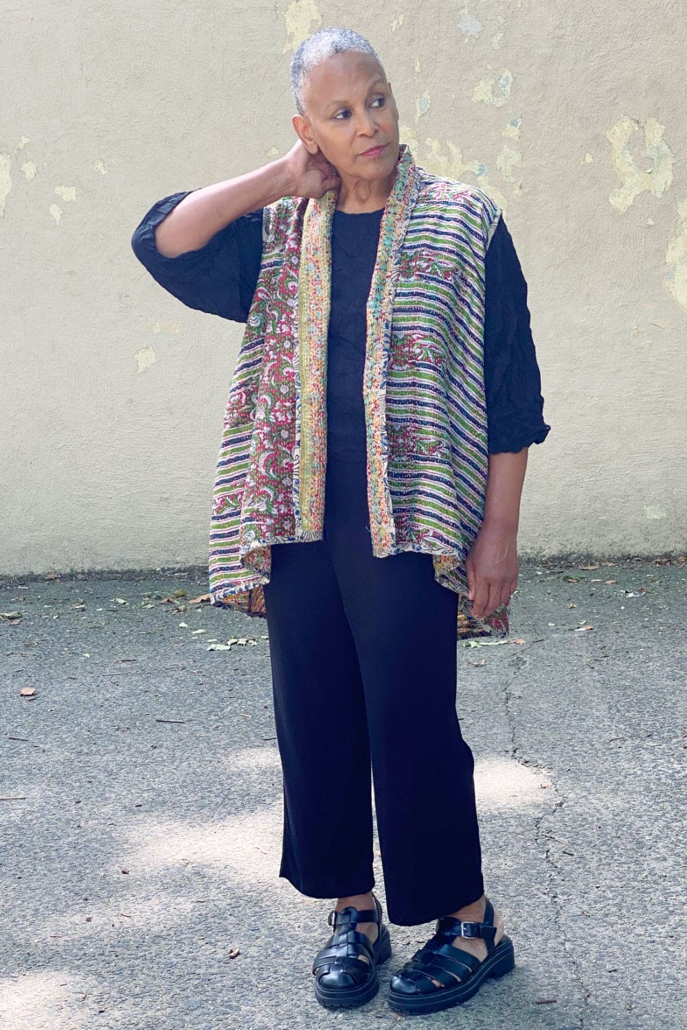 Older stylish woman wearing a Reversible silk vest with Kantha stitching.