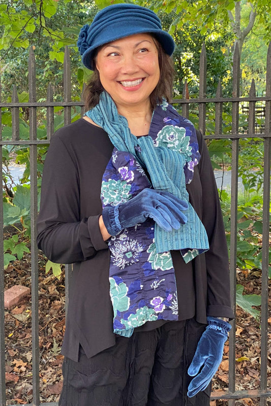 Fall winter accessories styled on a middle age model. Blue wool hat, reversible floral blue scarf and  blue vintage gloves.