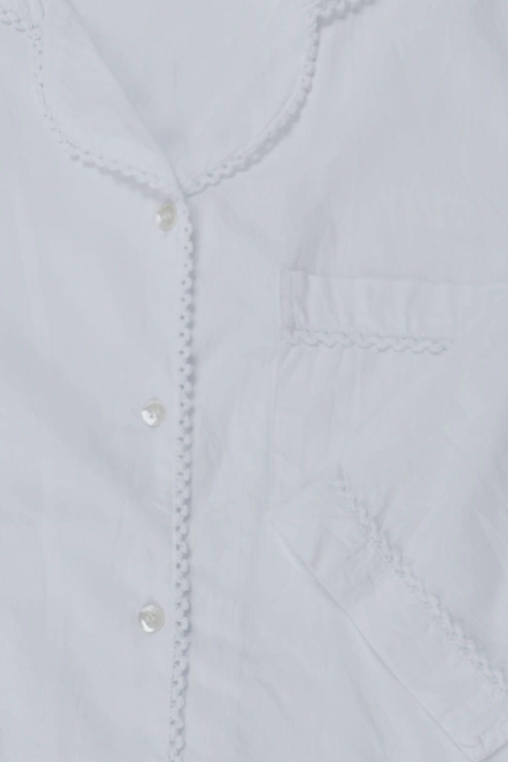 Close up of women's white night shirt. Pretty edging detail.