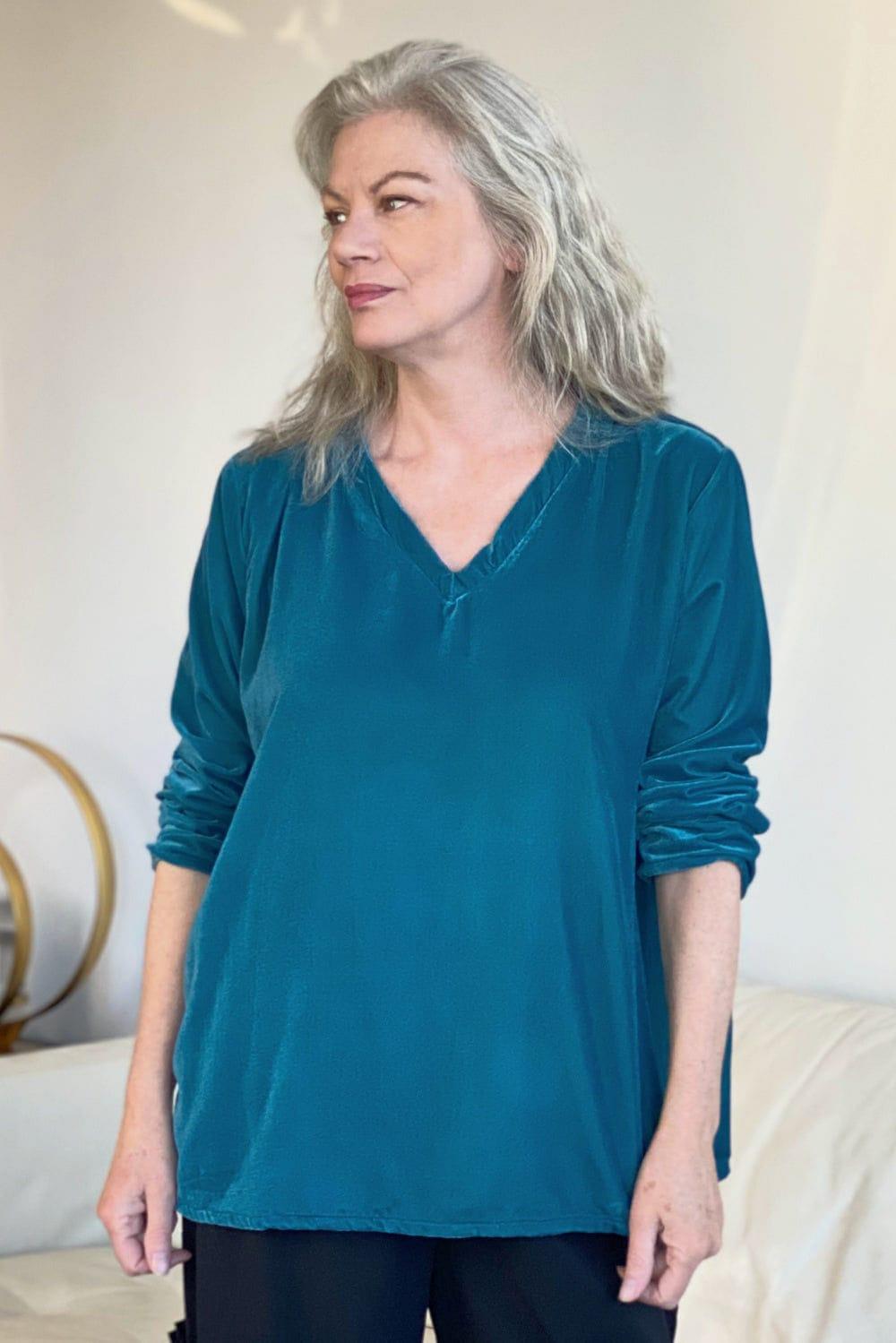 V neck Velvet top in a soft blue worn with black loose fit pants. 